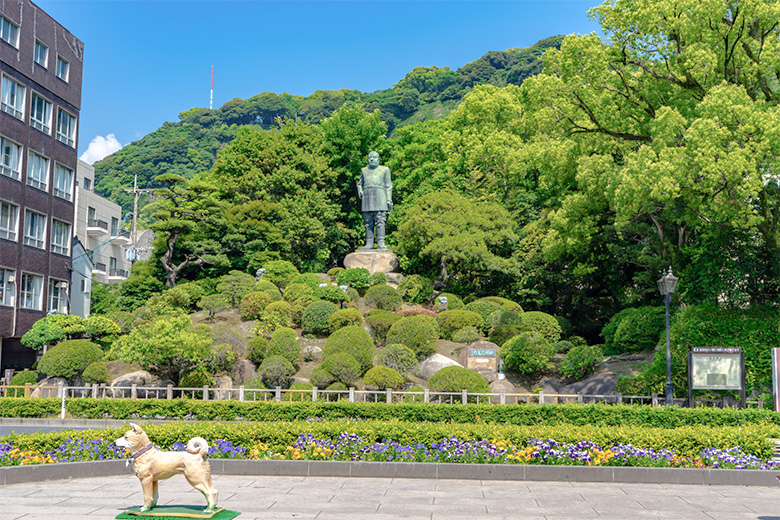 城山の麓に軍服姿で立つ西郷隆盛銅像